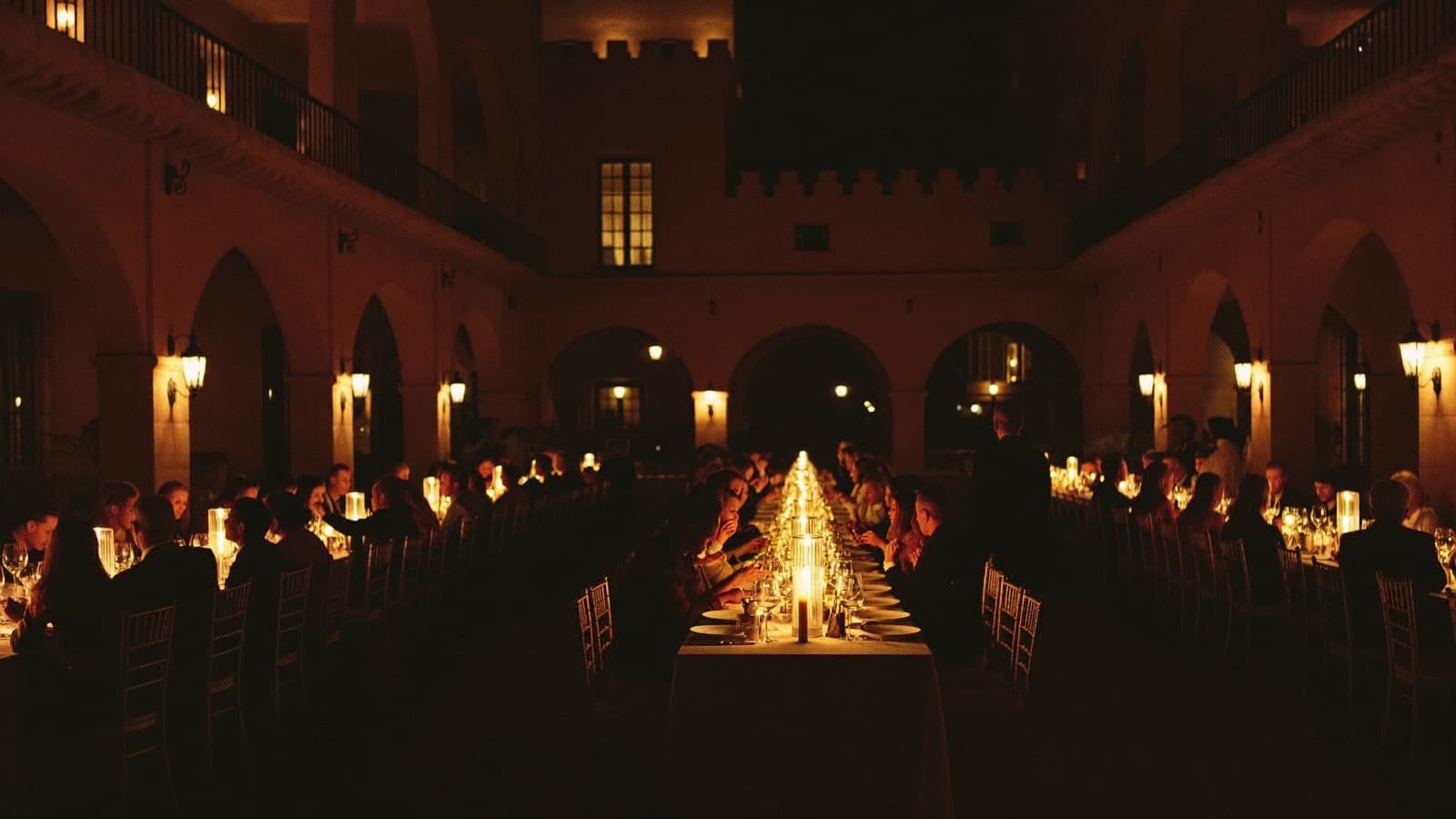 Cena de gala nocturna en un patio histórico durante La Cumbre